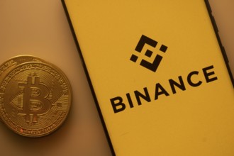 Bitcoin coin next to Binance logo on a yellow background, associated with crypto market
