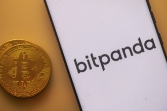 Bitcoin coin next to Bitpanda logo on a white background, involving digital investments