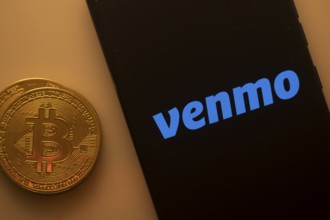 Venmo logo on smartphone screen beside Bitcoin, emphasizing digital transactions and payment