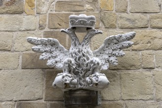 Stone relief of a crowned eagle, symmetrically and artistically embedded in a wall, St.Stephan's