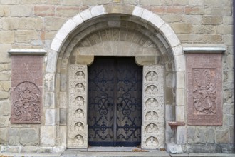 Historic stone door with reliefs and coats of arms, decorated medieval architecture, parish church