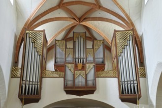 Close-up of an impressive church organ with ornate wooden details and arch structures, parish