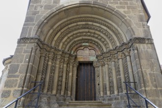 Romanesque stone door, ornate decoration and massive arches, staircases to the right and left, St