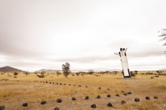 A mock Soviet rocket stands nose-first in the Solitaire, Namibian desert, surrounded by golden