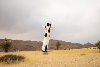A mock Soviet rocket stands nose-first in the Solitaire, Namibian desert, surrounded by golden