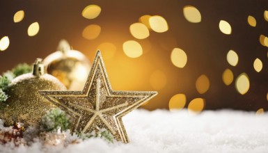 Golden christmas star and baubles creating a magical atmosphere on a snowy surface with warm bokeh