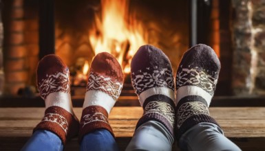 Couple relaxing with christmas socks by the fireplace on a cold winter evening, AI generated