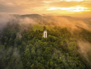 A foggy morning with a tower surrounded by green hills, Schönbergturm, Pfullingen, Swabian Alb,