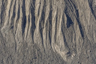 The earth's surface shows clear stripes and reliefs formed by erosion in dry regions. These natural