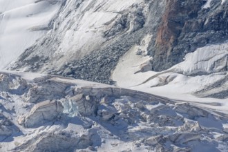 The mountainous landscape reveals impressive glaciers with ice formations and gleaming reflections