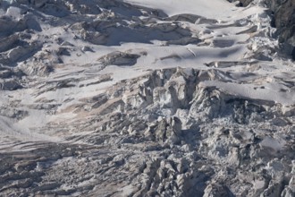 A spectacular glacier unfolds in the light, revealing its crevasses and layers of ice in a