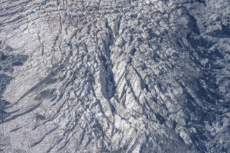 The mountainous landscape reveals impressive glaciers with ice formations and gleaming reflections