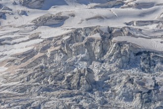 A spectacular glacier unfolds in the light, revealing its crevasses and layers of ice in a