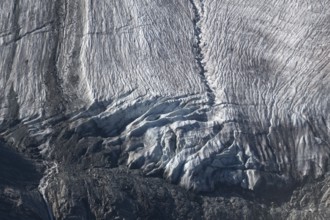 Impressive scene shows lines and textures on residual ice cream in mountains. Daylight emphasises
