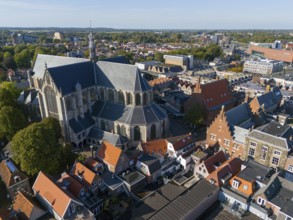 Large church in the middle of a cityscape with traditional houses and green trees, Aerial view,