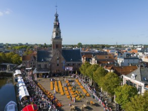 Historic market square with church and crowd under blue sky, aerial view, cheese, cheese market,
