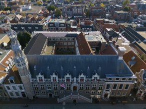 City view of a historic building with striking tower and red tiled roofs, aerial view, town hall,