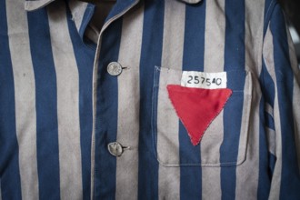 Copy of a blue and grey striped jacket of a concentration camp prisoner with a sewn-on number and