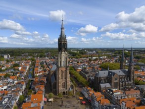 Historic church with high towers in a city with red roofs and clear skies, aerial view, Nieuwe