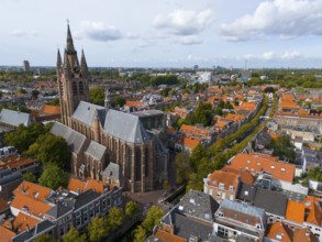 View of the historic city centre with large church and red roofs under a cloudy sky, aerial view,
