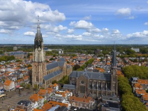City view with two churches and numerous red roofs under a cloudy sky, aerial view, Nieuwe Kerk,