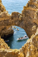 Crowds of excursion boats at the caves and rocky gates of the Ponta da Piedade rocky coast, rugged