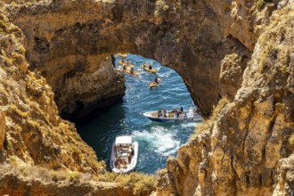 Crowds of excursion boats at the caves and rocky gates of the Ponta da Piedade rocky coast, rugged