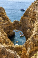 Crowds of excursion boats at the caves and rocky gates of the Ponta da Piedade rocky coast, rugged
