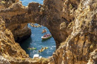 Crowds of excursion boats at the caves and rocky gates of the Ponta da Piedade rocky coast, rugged