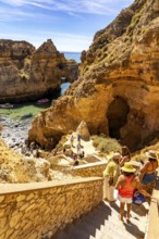 Tourists at the caves and rocky gates of the Ponta da Piedade rocky coast, rugged coastal