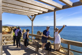 Tourists on the rocky coast of Ponta da Piedade, rugged coastal landscape, right next to Lagos city
