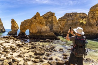 Tourists at the caves and rocky gates of the Ponta da Piedade rocky coast, rugged coastal