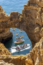 Crowds of excursion boats at the caves and rocky gates of the Ponta da Piedade rocky coast, rugged