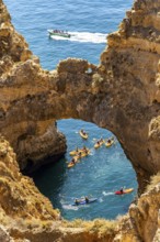 Crowds of excursion boats at the caves and rocky gates of the Ponta da Piedade rocky coast, rugged