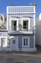 Facade of buildings decorated with tiles, azulejos, coloured tiles on facades, in Tavira, old town,