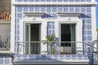 Facade of buildings decorated with tiles, azulejos, coloured tiles on facades, in Tavira, old town,