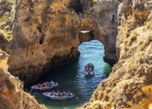 Excursion boats at the caves and rocky gates of the Ponta da Piedade rocky coast, rugged coastal