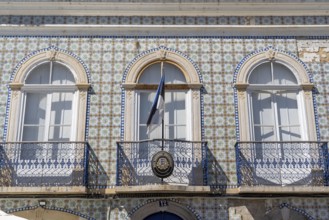 Facade of buildings decorated with tiles, azulejos, coloured tiles on facades, in Tavira, old town,
