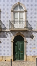 Facade of buildings decorated with tiles, azulejos, coloured tiles on facades, in Tavira, old town,