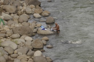 Old man washing his clothes in the river, Negros Occidental, Philippines