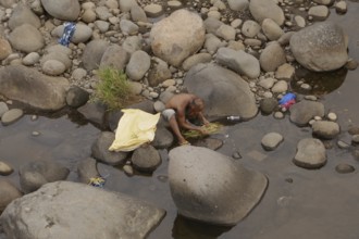 Man washing vegetables in the river, Negros Occidental, Philippines