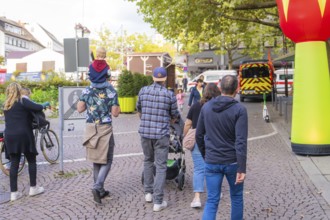Group of people strolling through town with prams and children on their shoulders, Sindelfingen,