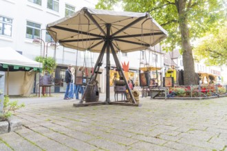 An empty, wooden carousel stands on a cobbled market square, Sindelfingen, Böblingen district,