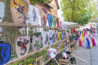 Various colourful coats of arms and children's toys on display at a market, Sindelfingen, Böblingen