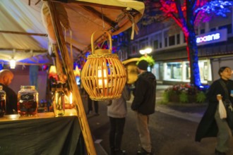 Atmospheric night-time street scene with decorative lanterns and market stalls, Sindelfingen,