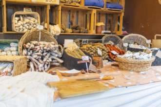 Various types of sausage presented on a market stall with baskets and wooden crates, Sindelfingen,
