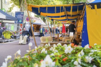 Colourful market scene with tents, flowers and people in motion, Sindelfingen, Böblingen district,