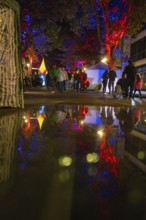 Colourful night lights reflected in a rain-soaked street during an event, Sindelfingen, Böblingen