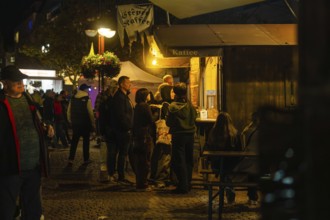 People waiting at an illuminated food stall at night, Sindelfingen, Böblingen district, Germany