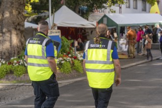 Two people in safety waistcoats on a market square, Sindelfingen, Böblingen district, Germany
